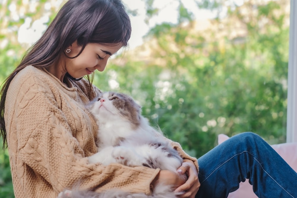 Owner hugging her cat